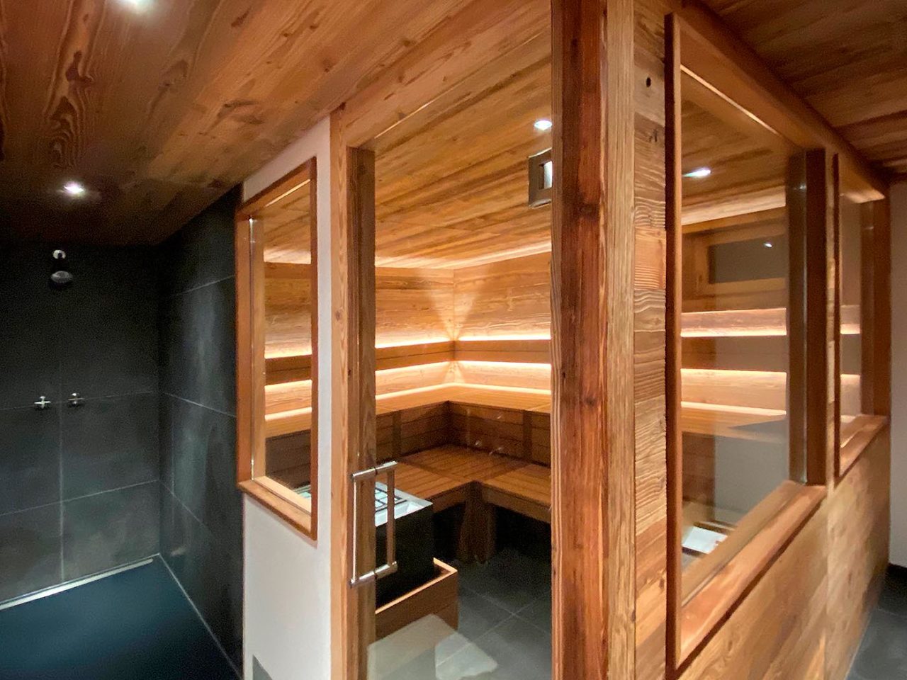 Custom-made reclaimed old wood sauna in the basement with shower right next to it