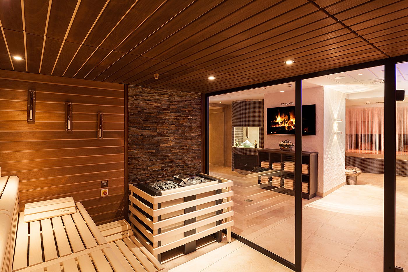 Espace bien-être avec sauna à l’hôtel Sauerland Stern: sauna bio avec façade en verre et grand poêle sauna pour des infusions vigoureuses. made by corso sauna manufaktur