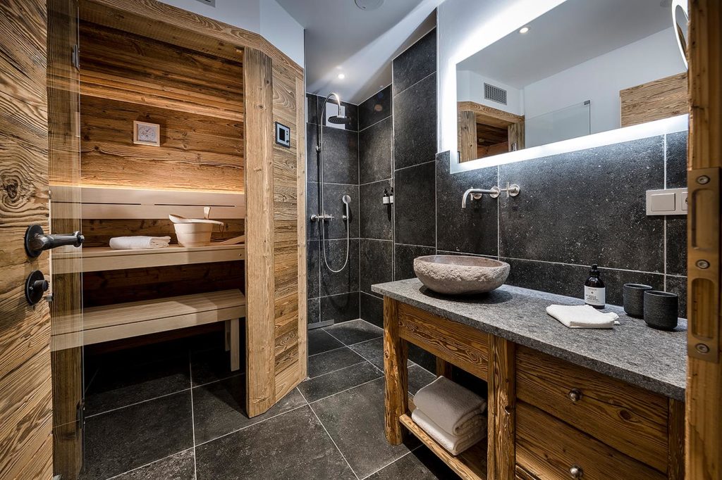 Urgemütliche Sauna aus Altholz mit Glasfront: private Sauna in der Suite des Chiemsee Chalets