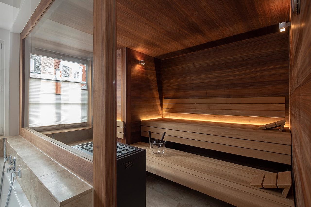 Design Sauna im Altbau mit Dachschräge und Glasfront in Nussbaum 