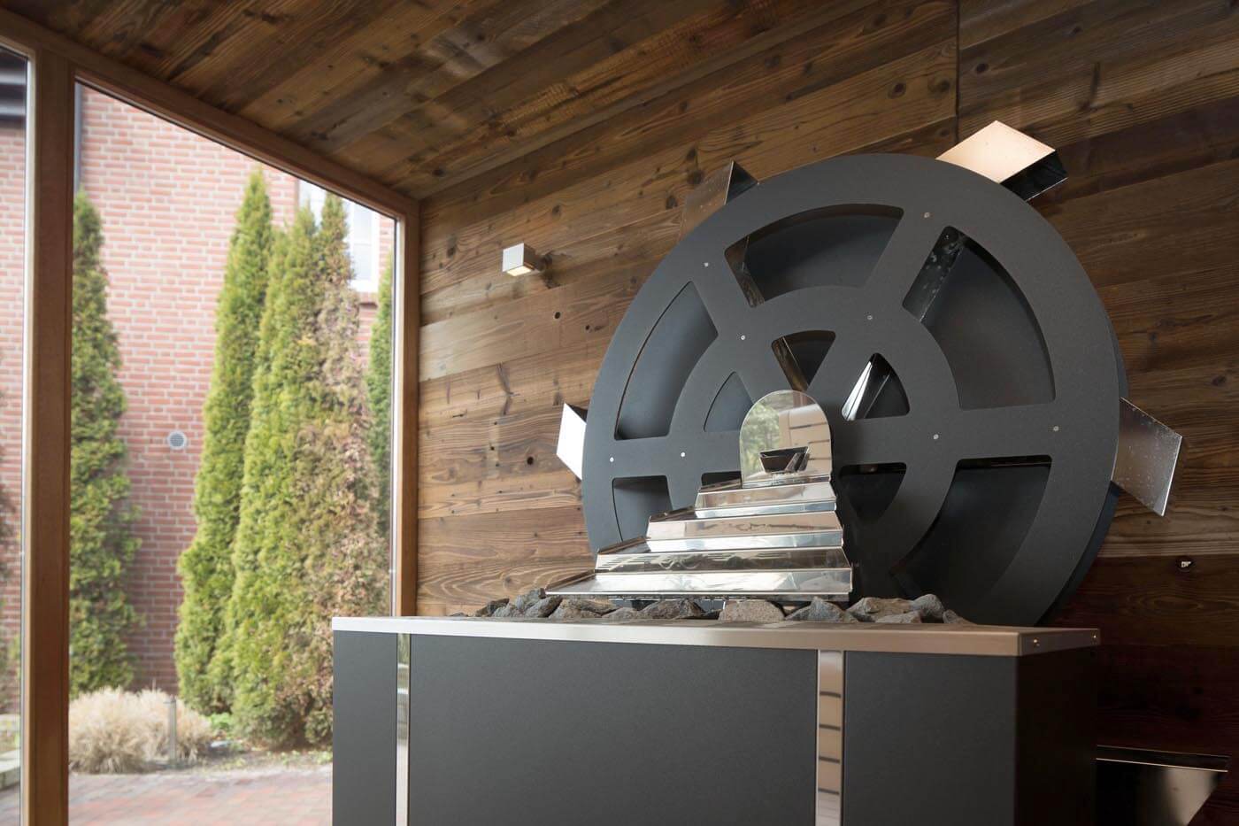 Sauna Automation: vollautomatische Aufgüsse in der Hotelsauna mit dem Mühlenradofen. Saunahersteller corso, Maßanfertigung.