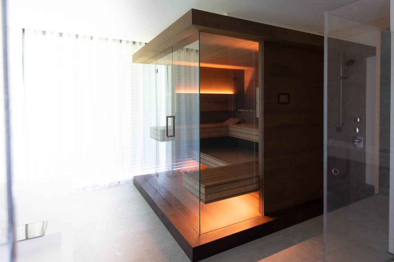 Sauna mit Glasfront im Badezimmer: Dreiseitig verglaste Designsauna als Variation der NIMBUS Sauna mit LED Beleuchtung im Bad.