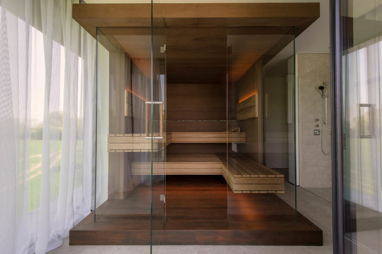 Premium Sauna mit Glasfront im Badezimmer: Dreiseitig verglaste Designsauna als Variation der Sauna NIMBUS mit LED Beleuchtung im Bad.