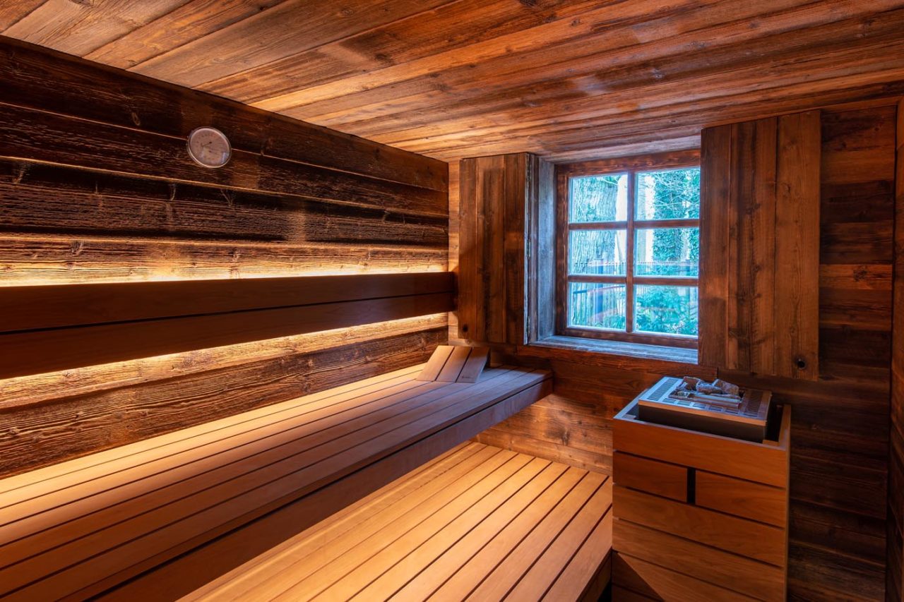 Family sauna home made of reclaimed wood with a view from the window directly into the garden