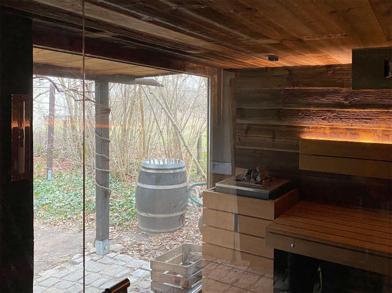 Gartenschuppen, der zur Gartensauna umgebaut wurde: mit Altholz und Glasfront zum Garten