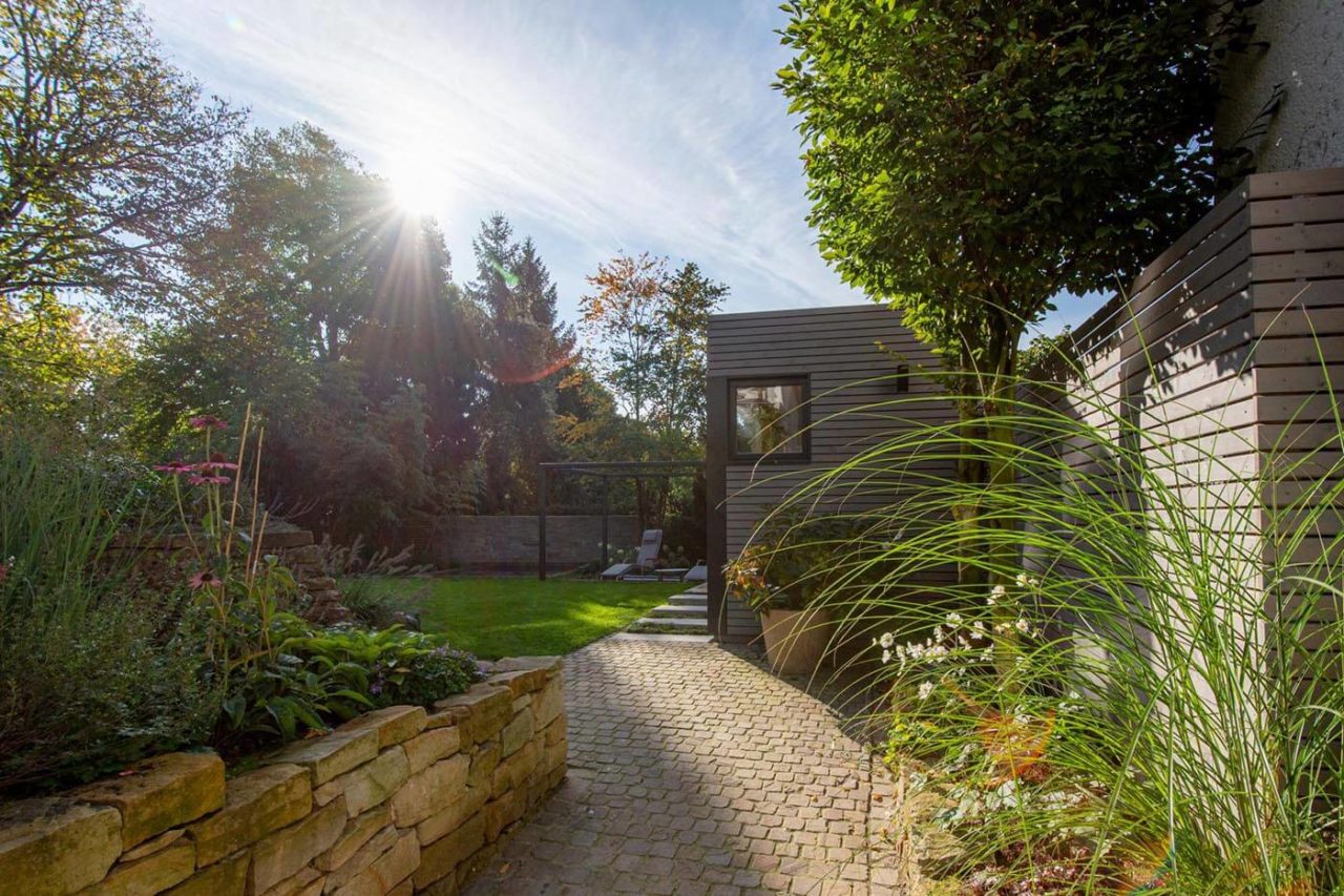 Moderne Außensauna nach Maß im Garten mit Teilverglasung und Ruheraum. Außenverkleidung in Rhombus-Profilholz.