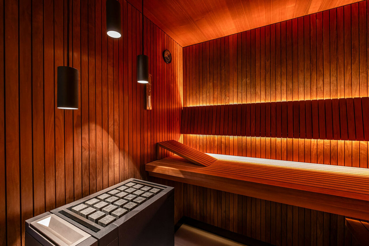 Design Sauna nach Maß mit Glasecke in Thermo-Espe Stäbchenoptik mit indirekter LED Rückenlehnenbeleuchtung und Außenfenster. Biosauna. Saunabau Münster.