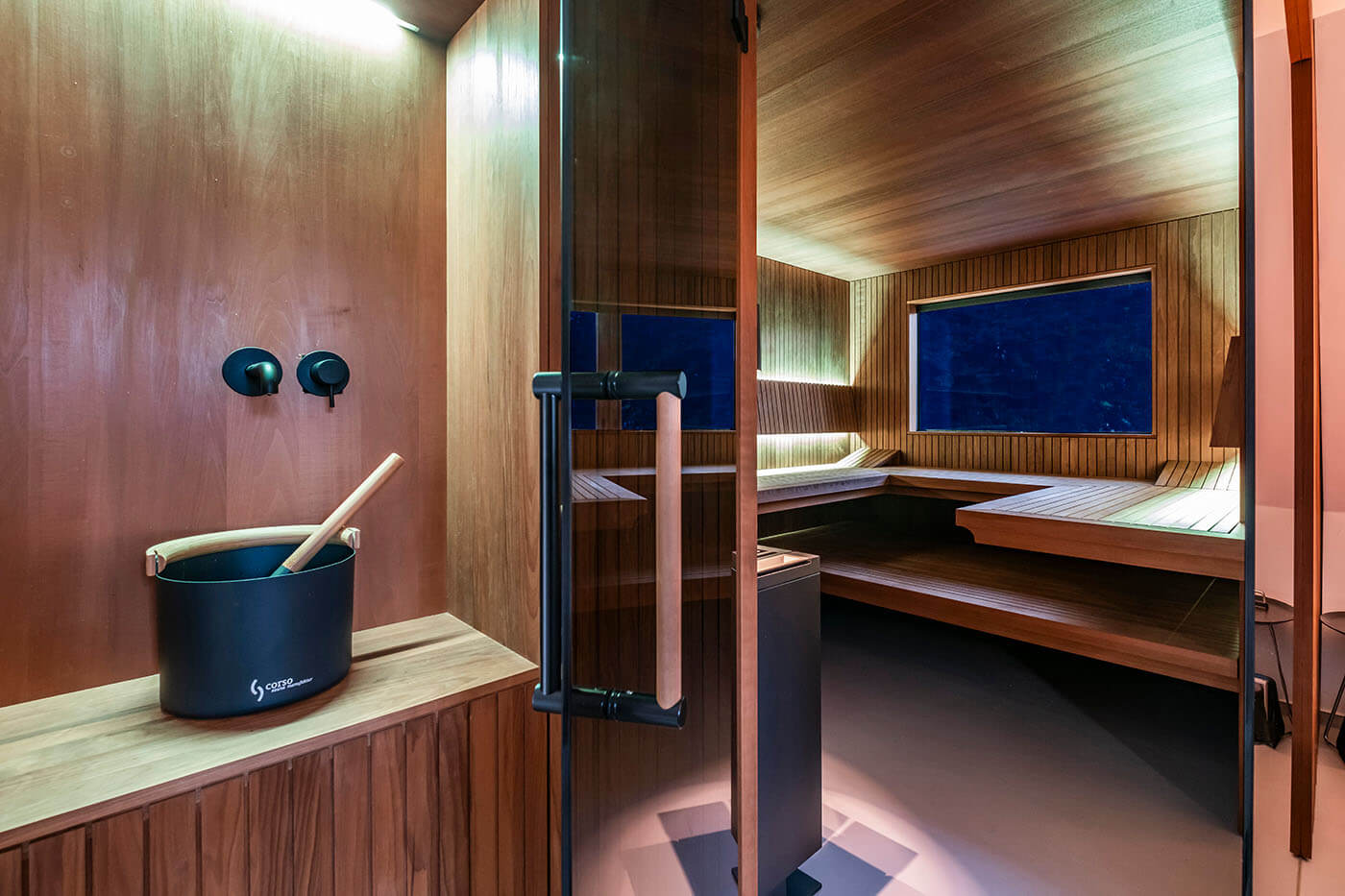 Design Sauna nach Maß mit Glasecke in Thermo-Espe Stäbchenoptik mit indirekter LED Rückenlehnenbeleuchtung und Außenfenster. Biosauna. Saunabau Münster.