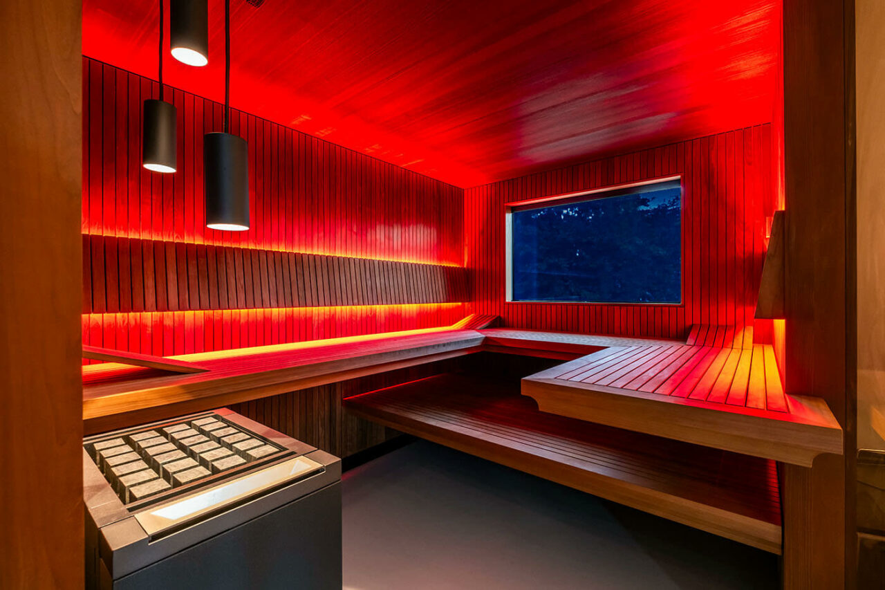 Design Sauna nach Maß mit Glasecke in Thermo-Espe Stäbchenoptik mit indirekter LED Rückenlehnenbeleuchtung und Außenfenster. Biosauna. Saunabau Münster.