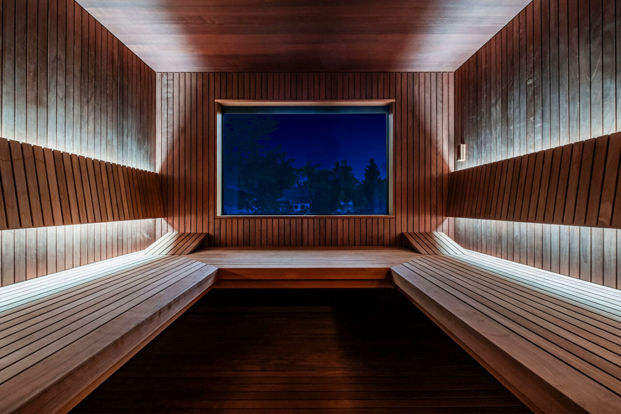Design Sauna nach Maß mit Glasecke in Thermo-Espe Stäbchenoptik mit indirekter LED Rückenlehnenbeleuchtung und Außenfenster. Biosauna. Saunabau Münster.