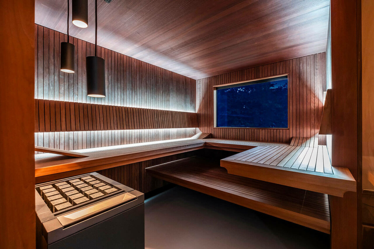 Design Sauna nach Maß mit Glasecke in Thermo-Espe Stäbchenoptik mit indirekter LED Rückenlehnenbeleuchtung und Außenfenster. Biosauna. Saunabau Münster.