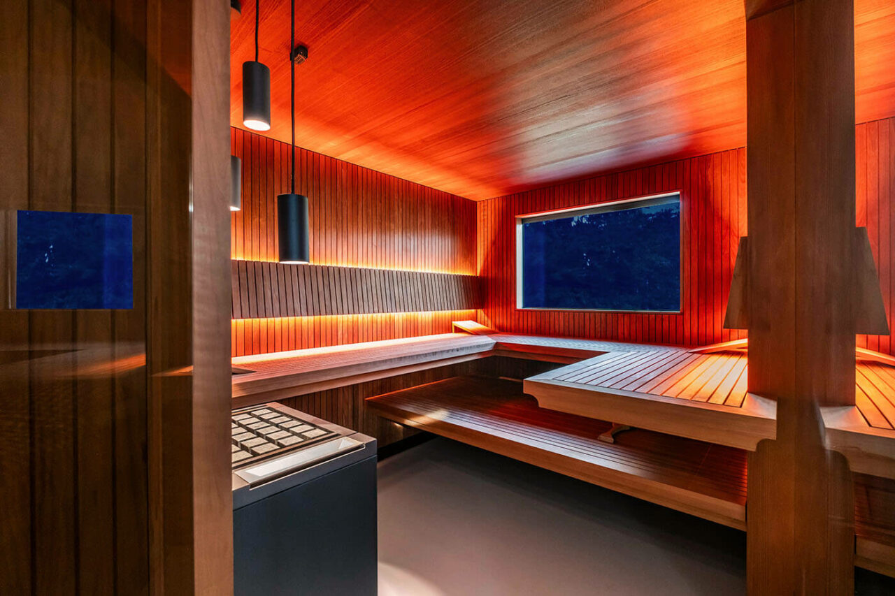Design Sauna nach Maß mit Glasecke in Thermo-Espe Stäbchenoptik mit indirekter LED Rückenlehnenbeleuchtung und Außenfenster. Biosauna. Saunabau Münster.