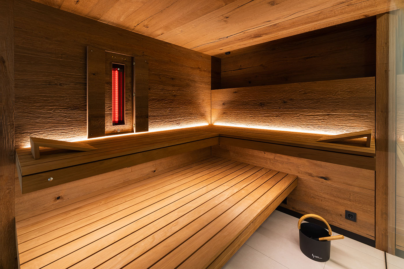 Premium Ecksauna in Eiche und Thermo-Espe mit zweiseitiger Verglasung, schwebenden Bänken, Hinterwandofen und verdeckt eingebautem Infrarot Strahler