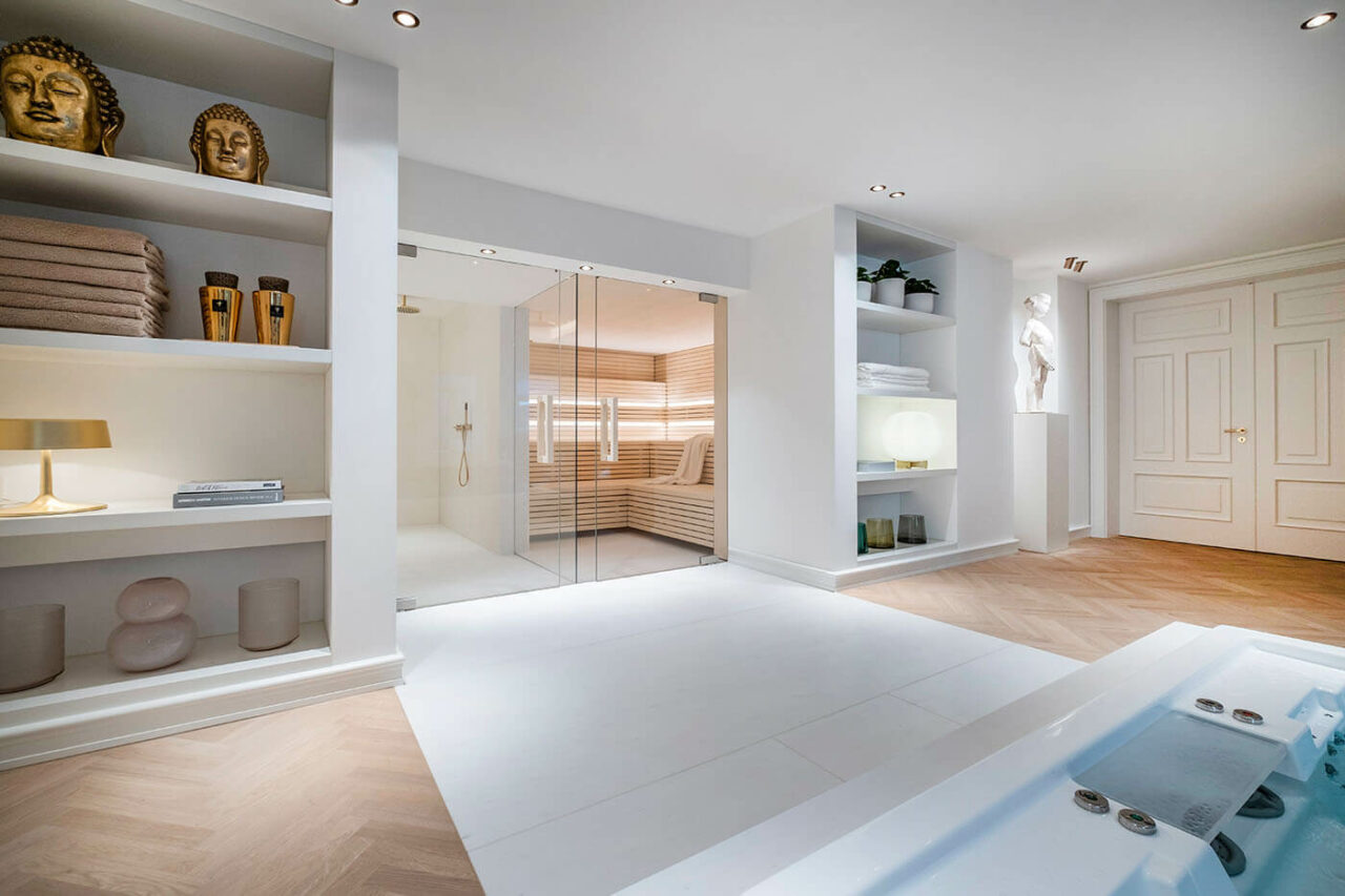 Design Sauna im Bauhausstil mit Hinterwandofen. Saunaholz: helle Espe in Stäbchenoptik. Große Glasfront, LED Beleuchtung, Hinterwandofen.