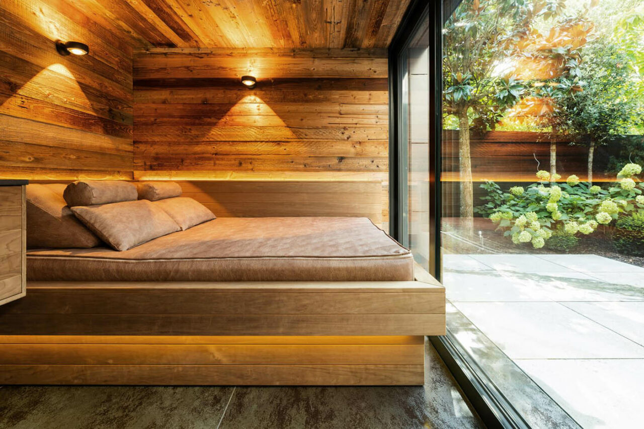 Luxus Außensauna: individuell geplante und gebaute Gartensauna in Altholz mit Sauna, Ruheraum mit Wasserbett und Regendusche von Dornbracht sowie Verdunkelung von Warema