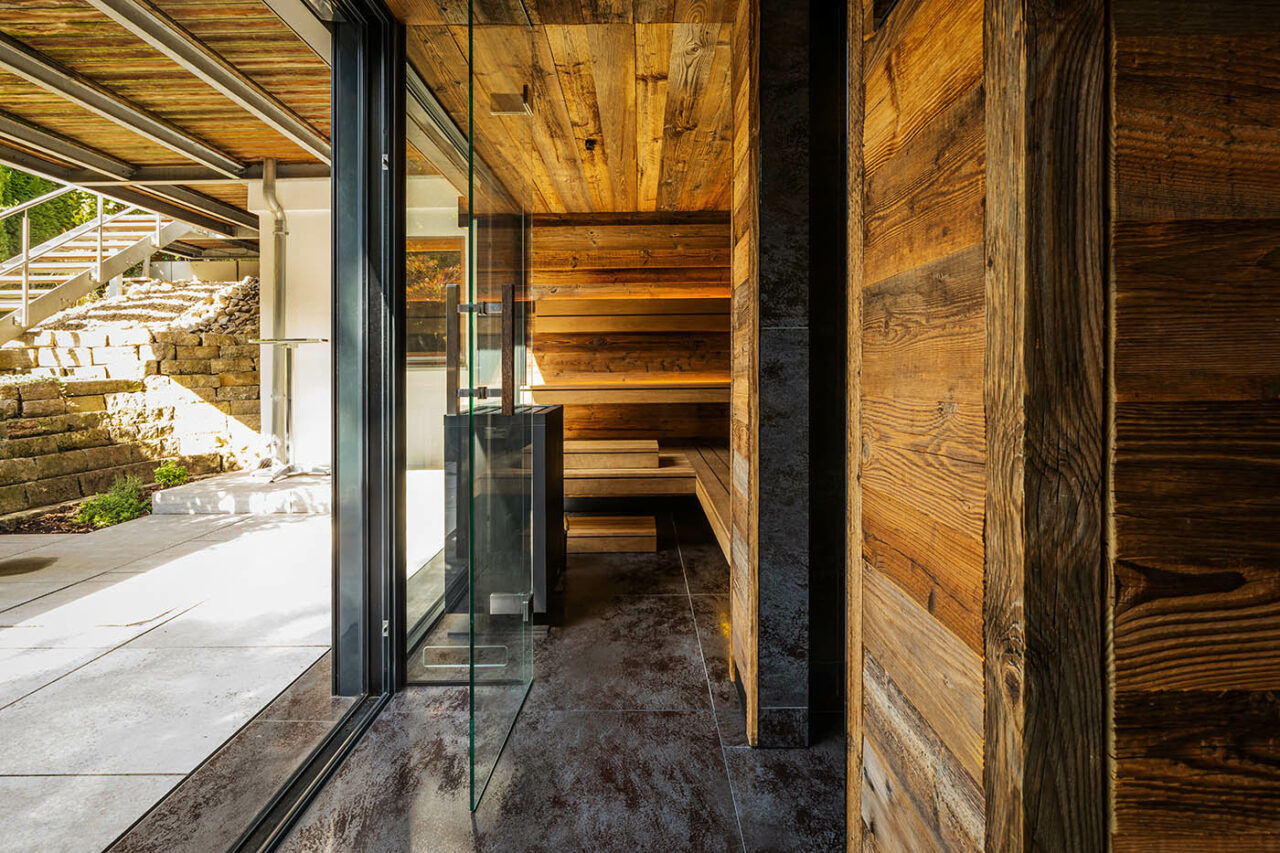Luxus Außensauna: individuell geplante und gebaute Gartensauna in Altholz mit Sauna, Ruheraum mit Wasserbett und Regendusche von Dornbracht