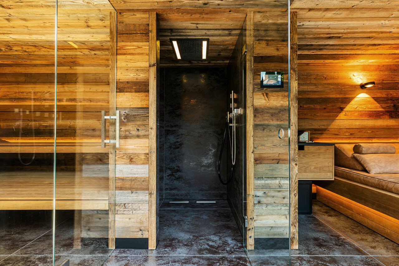 Luxus Außensauna: individuell geplante und gebaute Gartensauna in Altholz mit Sauna, Ruheraum mit Wasserbett und Regendusche von Dornbracht sowie Verdunkelung von Warema