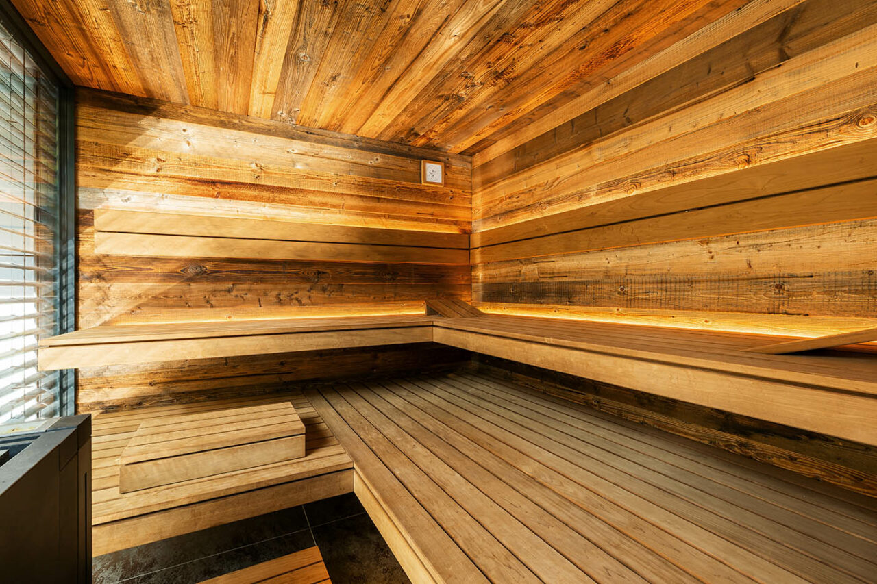 Luxus Außensauna: individuell geplante und gebaute Gartensauna in Altholz mit Sauna, Ruheraum mit Wasserbett und Regendusche von Dornbracht sowie Verdunkelung von Warema
