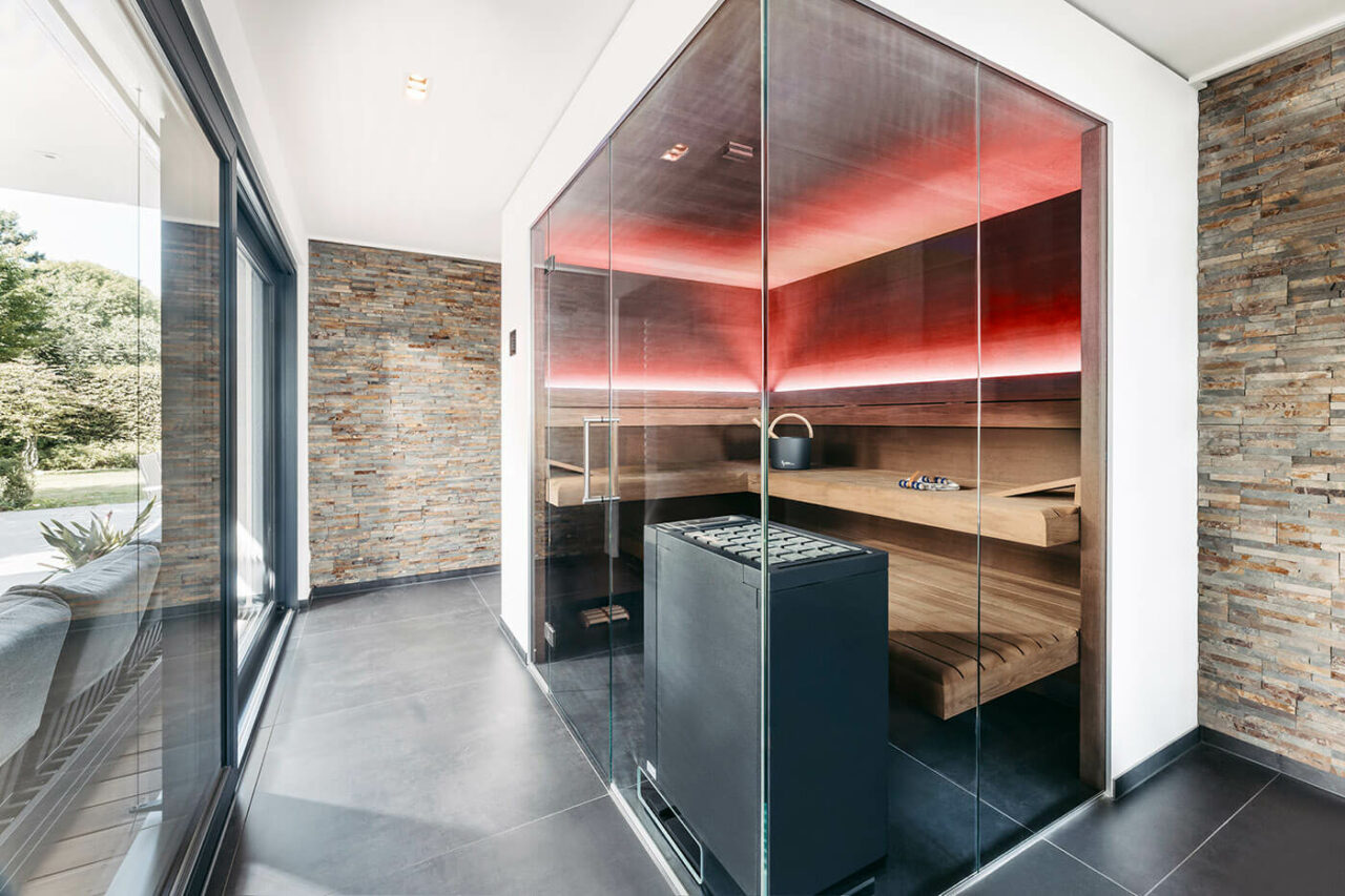 Design Sauna mit Glasfront in Thermo-Eiche mit frei stehendem Saunaofen und LED Beleuchtung. Massanfertigung.