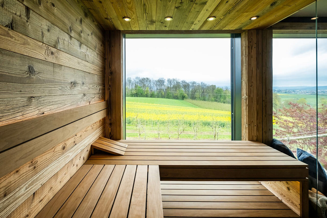 Sauna auf Garagendach: Altholzsauna in Maßanfertigung mit Glasfront und integriertem Außenfenster. Anbau bzw. Aubau auf dem Garagendach.