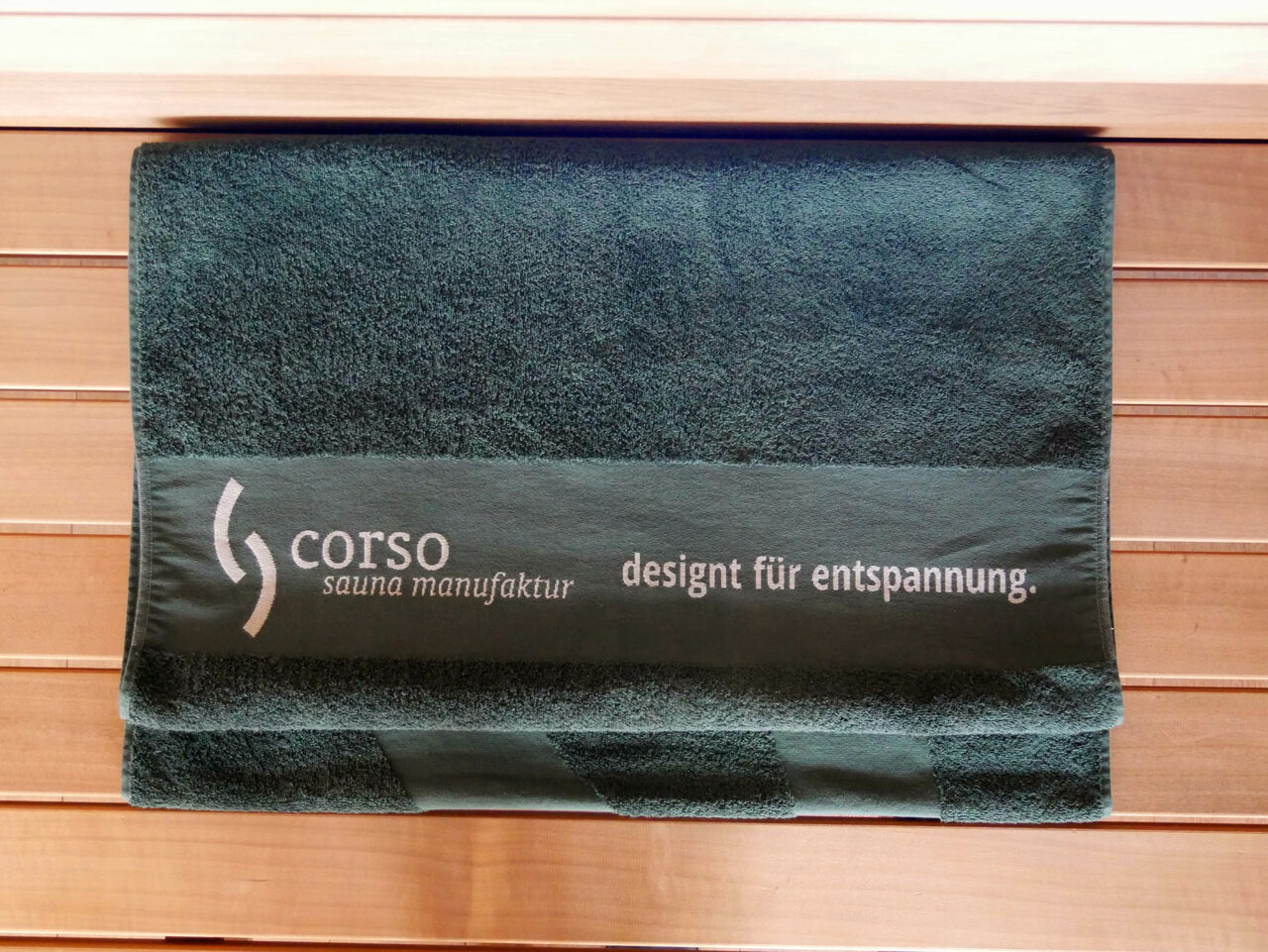 Sauna Zubehör: dunkelgrünes Saunahandtuch / Saunatuch XL mit corso Logo. Beste Qualität in Bio-Baumwolle. Extra groß mit 70 x 200 cm. Erhältlich im corso e-Shop für Saunazubehör.