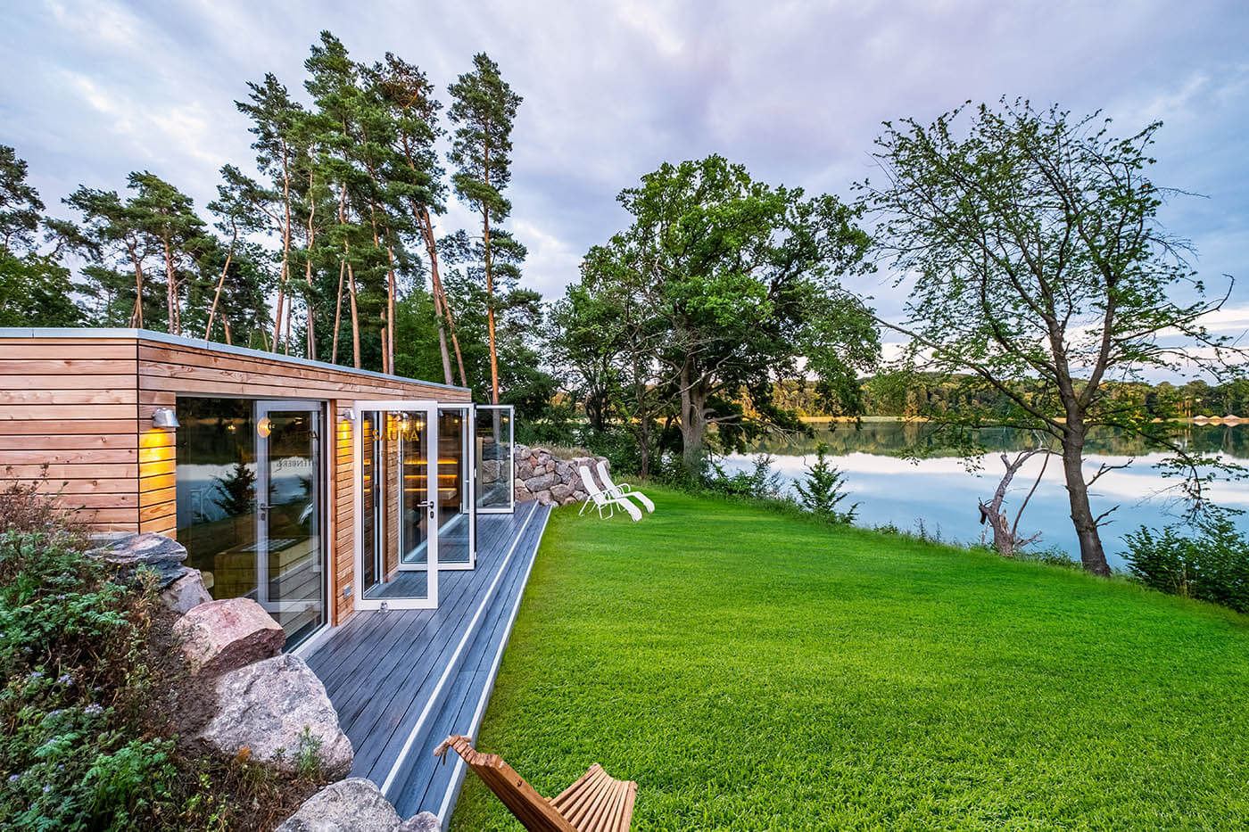 Saunahaus als Hotel SPA. Gartensauna im Außenbereich direkt am See beim Hotel Lichtenberg mit Ruheraum und Dusche. Innengestaltung in Altholz, Außengestaltung passend zum Hotel.