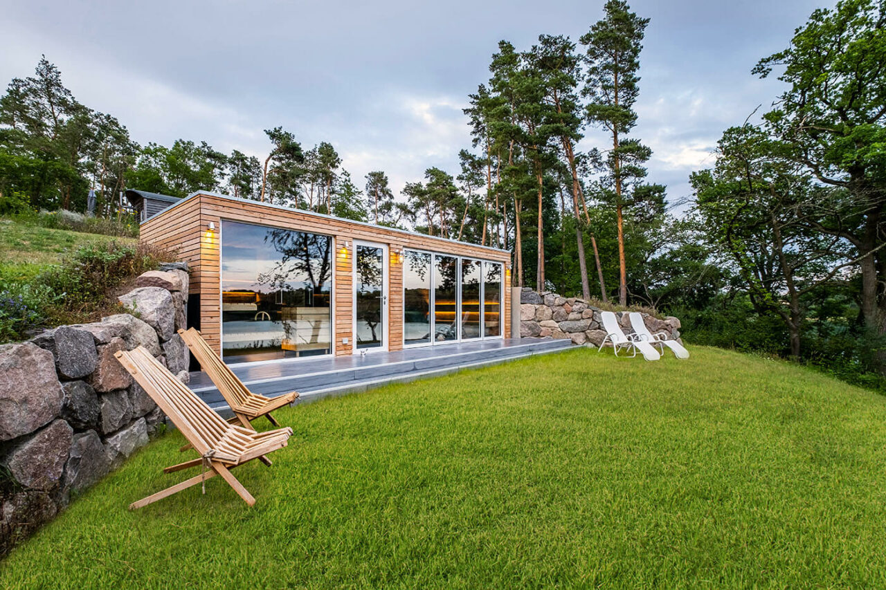 Außensauna Hotel: Gartensauna im Außenbereich direkt am See beim Hotel Lichtenberg mit Ruheraum und Dusche. Innengestaltung in Altholz, Außengestaltung passend zum Hotel.