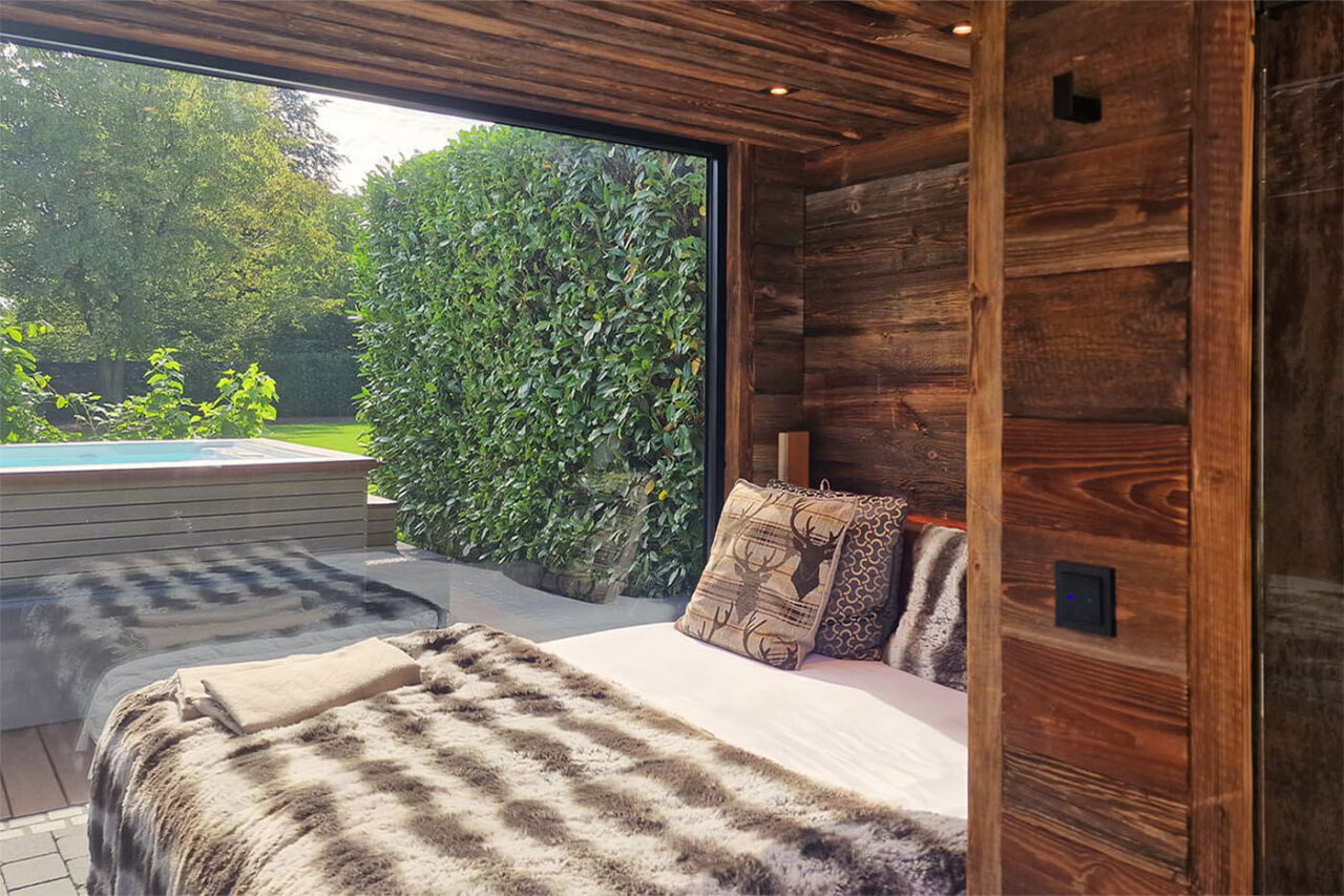 Gartensauna mit Ruheraum: Blick aus dem Ruheraum in den Garten mit Whirlpool