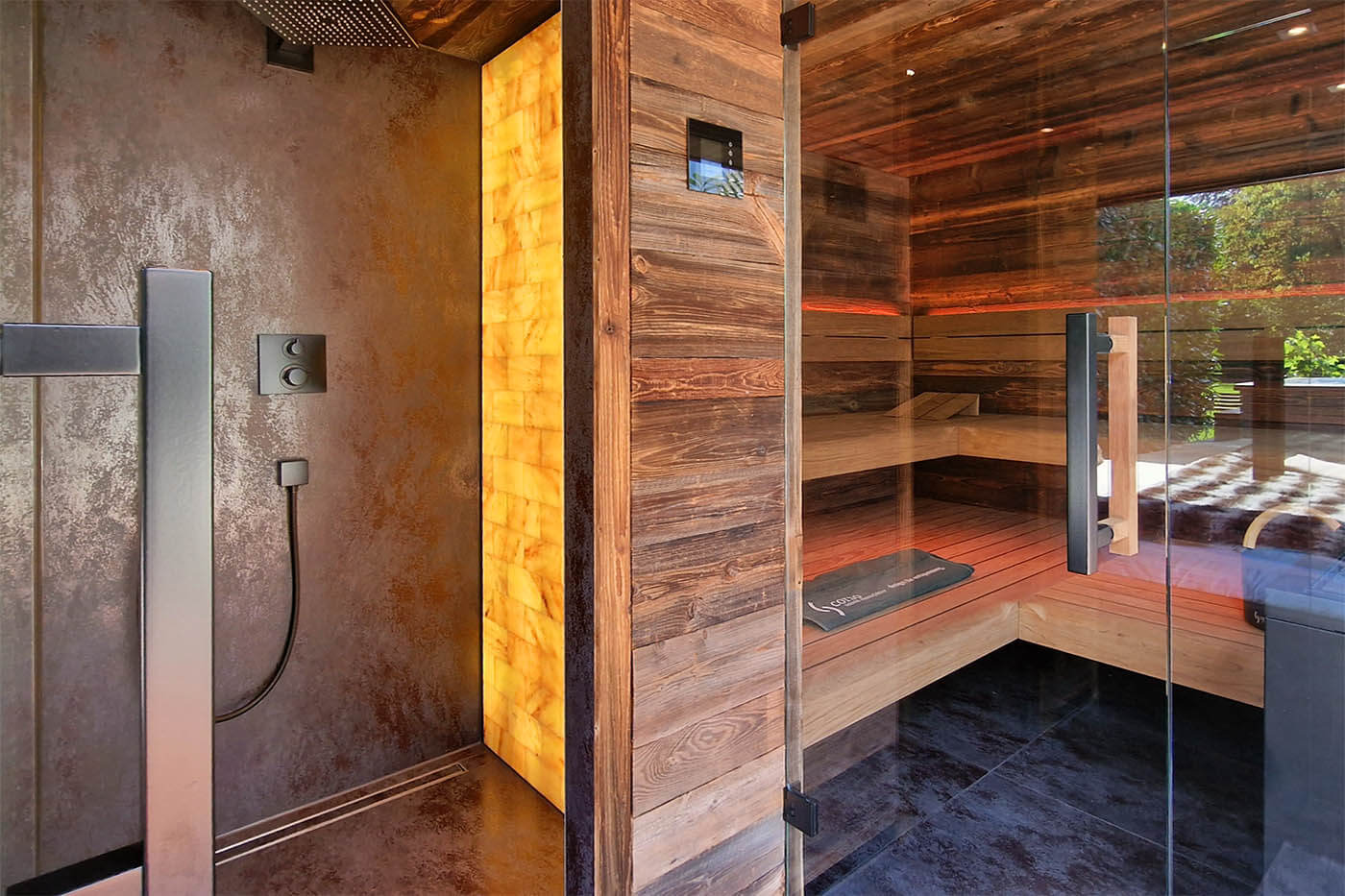 Gartensauna mit Dusche und Ruheraum: Blick in die schwarz gestaltete Dusche mit Salzsteinwand.