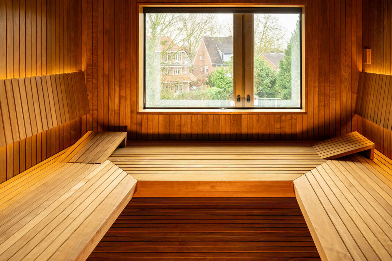 Design Sauna nach Maß mit Glasecke in Thermo-Espe Stäbchenoptik mit indirekter LED Rückenlehnenbeleuchtung und Außenfenster. Biosauna. Saunabau Münster.