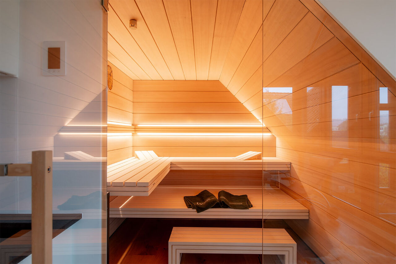 Sauna nach Maß: Hemlock Sauna mit Dachschräge und großer Glasfront.