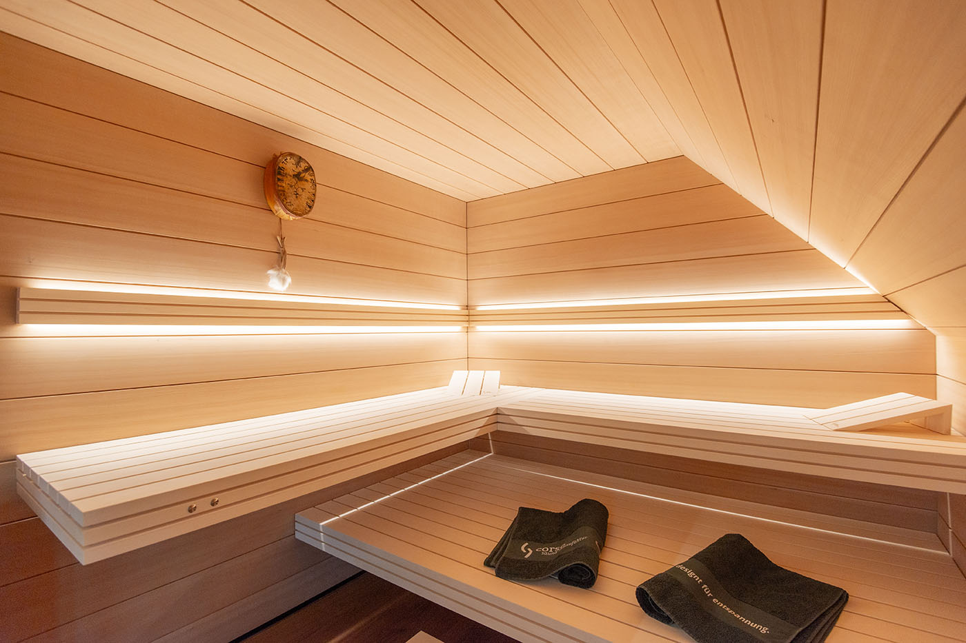 Sauna nach Maß: Hemlock Sauna mit Dachschräge und großer Glasfront.
