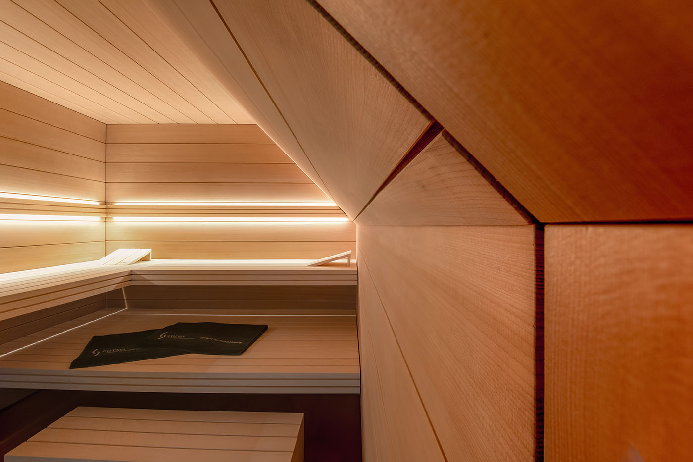 Sauna nach Maß: Hemlock Sauna mit Dachschräge und großer Glasfront.