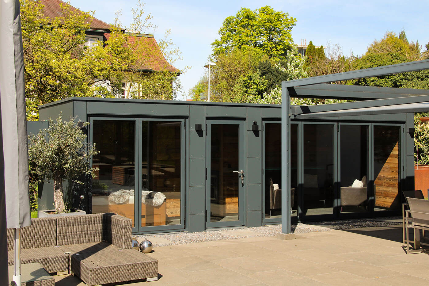 Custom-made pool house with opening glass front, daybed, coffee kitchen and lounge. Exterior cladding in weatherproof Trespa laminate panels.