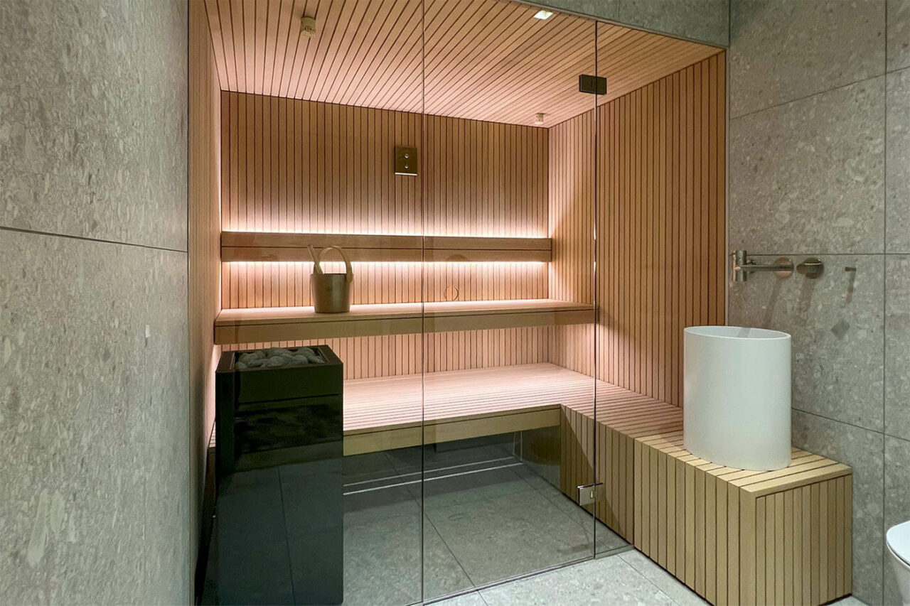 Hemlock Sauna in Stäbchenoptik als Maßanfertigung mit großer Glasfront und nach außen verlängerter Bank. Direkt vom Saunabauer.