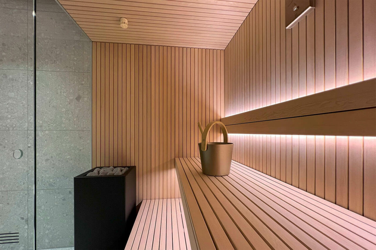 Hemlock Sauna in Stäbchenoptik als Maßanfertigung mit großer Glasfront und nach außen verlängerter Bank. Direkt vom Saunabauer.