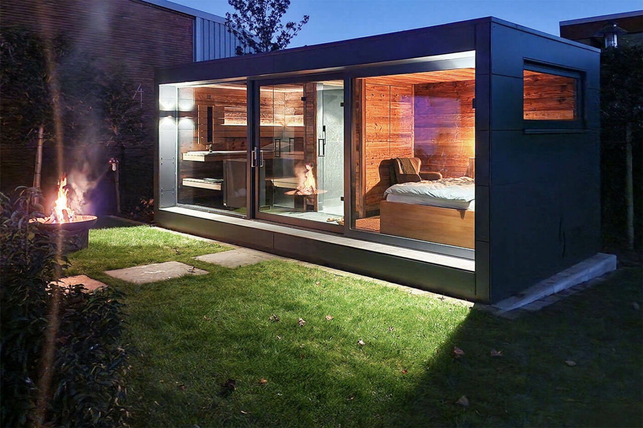 Gartensauna mit Daybed und Dusche in Altholz. Glasfront mit Schiebetür.