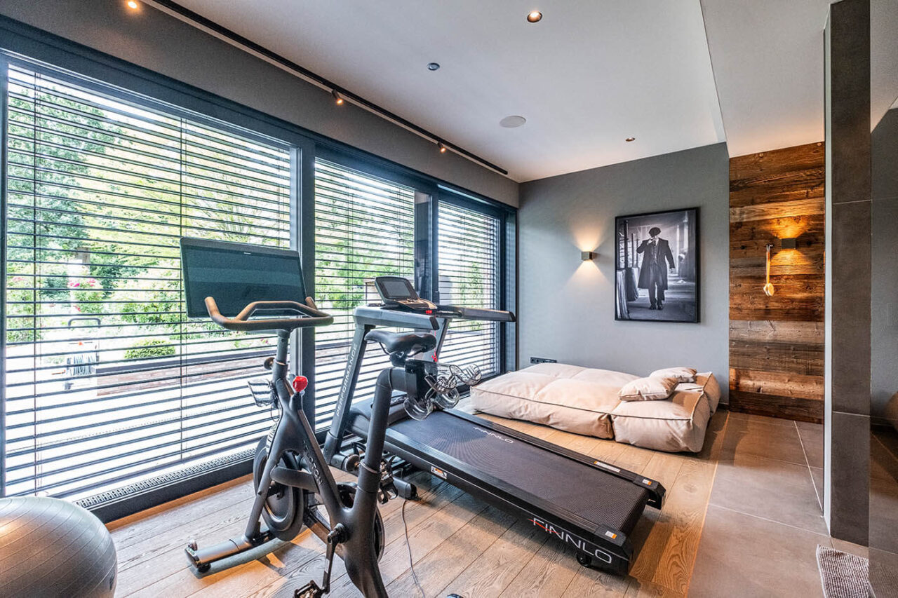 Altholzsauna mit Glasfront und nach außen fortgeführter Wand. Maßanfertigung direkt neben der Dusche.