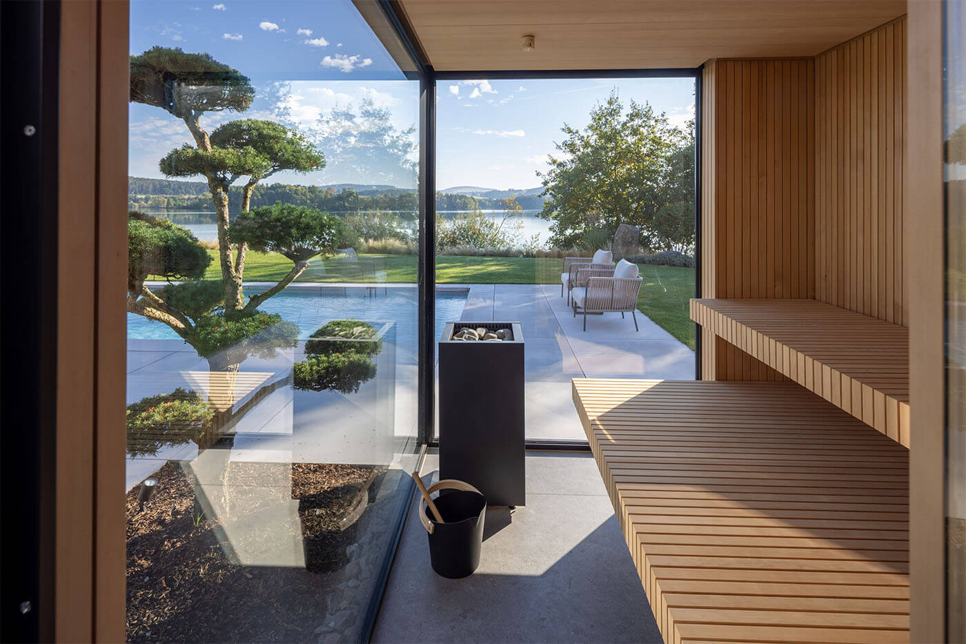 Gartensauna am Pool in Hemlockholz Stäbchenoptik mit gerader Vorderkante. Indirekte Beleuchtung mit LED.